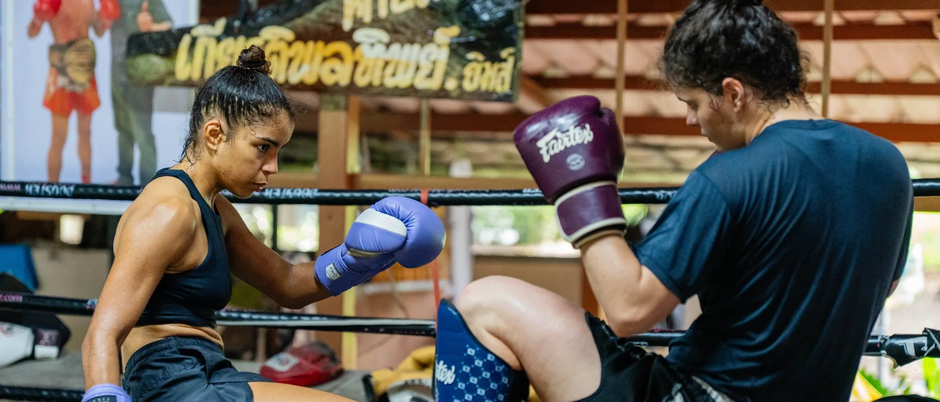 Woman training in the ring with a partner at Kiatphontip Muay Thai camp, Bangkok