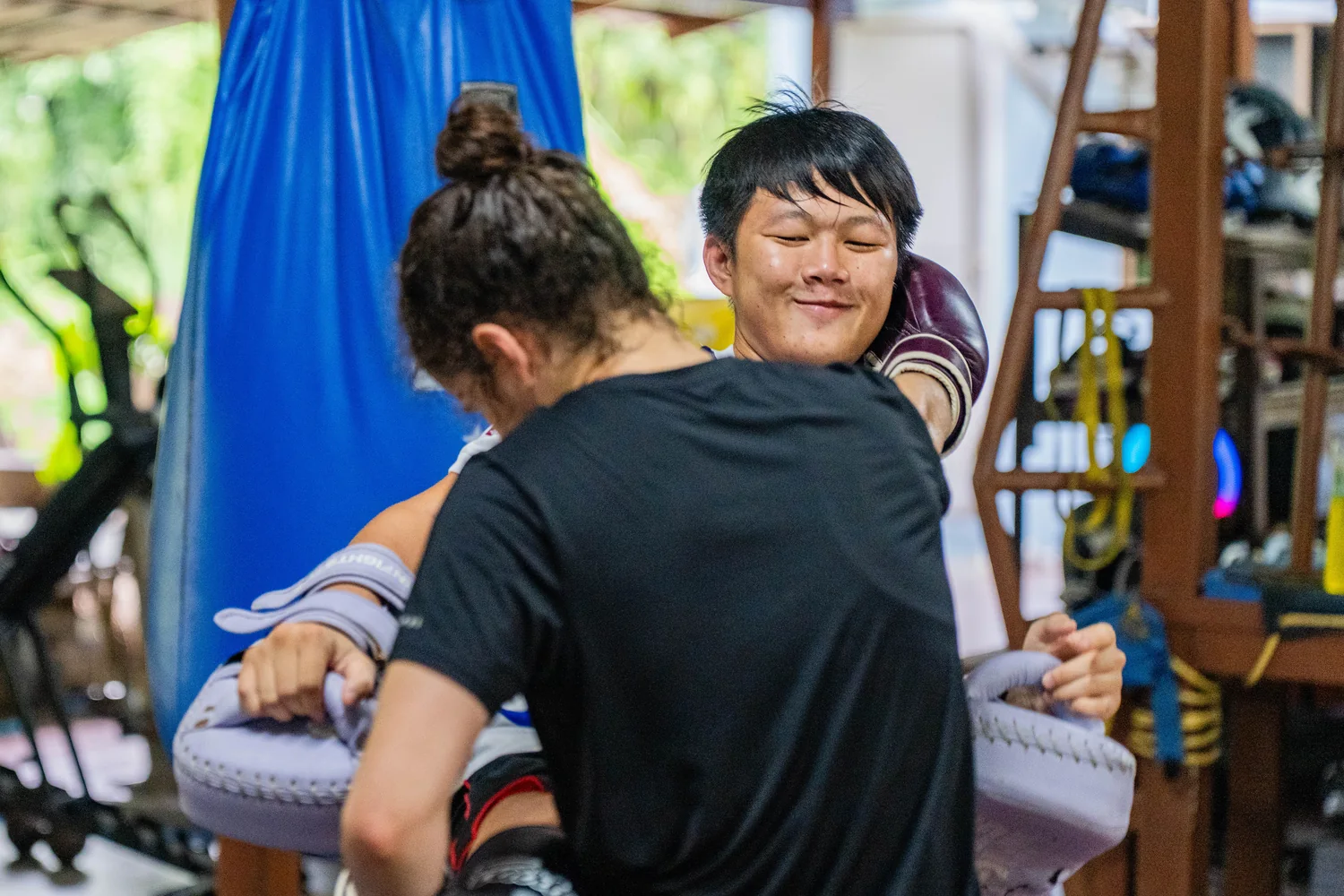 A smiling student on the pads at the Kiatphontip camp