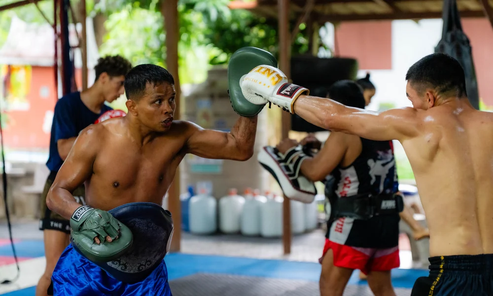 Beginner learning Muay Thai on the pads at Kiatphontip Bangkok